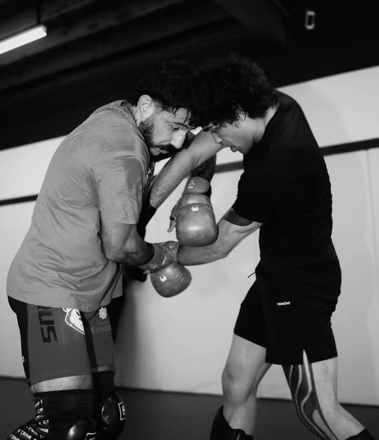 Two fighters in a clinch during a training session
