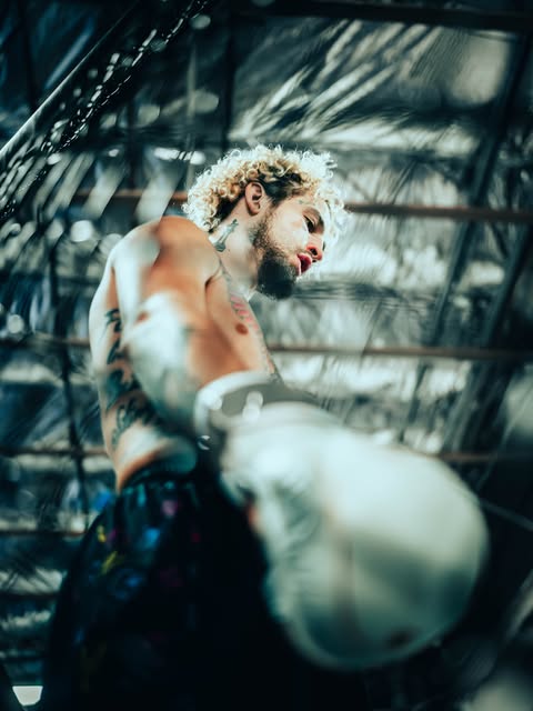 Fighter shot from a low angle inside the cage, glove in the foreground